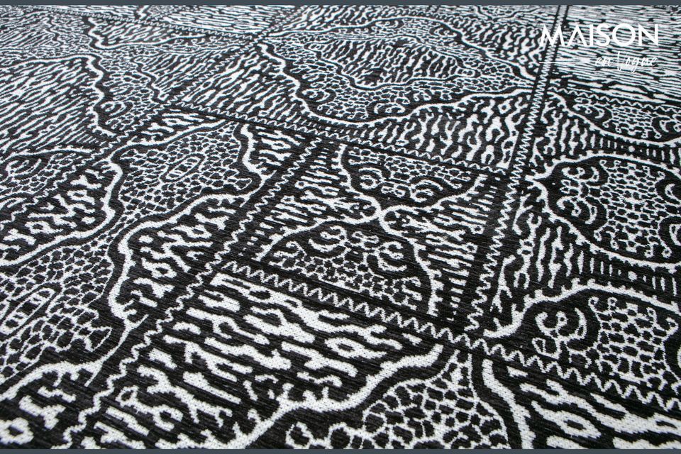 Esta gran alfombra de tela Renna en blanco y negro tiene un estampado estético