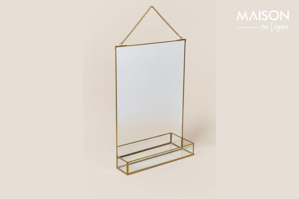 Un espejo y su estante resaltado por un acabado dorado