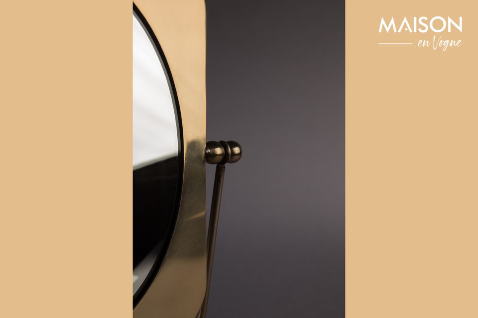 El espejo Pris es un accesorio lacado de latón cuyos reflejos dorados le dan encanto y elegancia