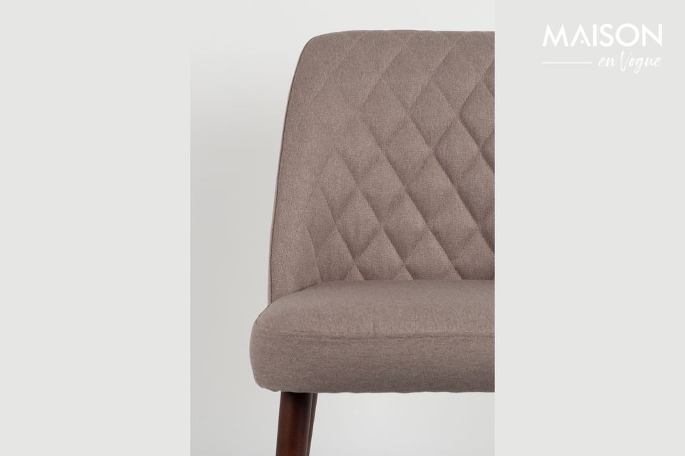 Una silla con un asiento tapizado y un diseño clásico